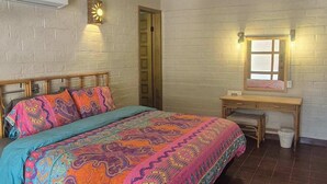 Un dormitorio con una cama, un escritorio y una silla.