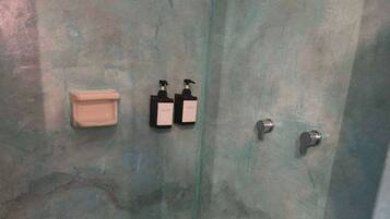 Chuveiro, toalhas de banho, shampoo