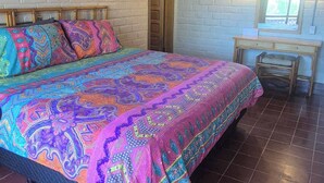 Ein Zimmer mit Bett, Schreibtisch, Stuhl, Fenster und Tür.