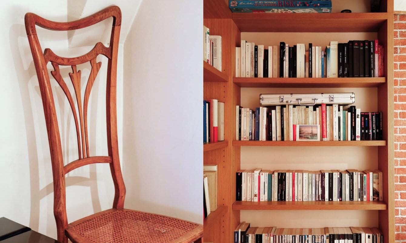 A wooden chair with a woven seat and a bookshelf with multiple shelves filled with books.