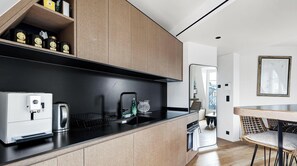 A modern kitchen with a built-in coffee machine, a kettle, and a water dispenser. - Luxe sous les toits, vue Tour Eiffel & A/C (Paris)