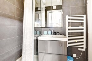 Ein Badezimmer mit Spiegel, Waschbecken und Handtuchhalter.