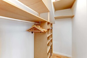 Ein begehbarer Kleiderschrank mit Holzböden und Kleiderstange.