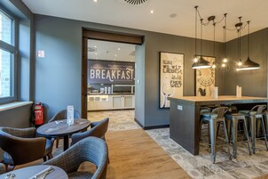 Un área de desayuno moderna con mostrador, asientos y un letrero que dice 'BREAKFAST'.