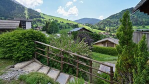 A rural village with traditional wooden houses, a wooden staircase, and a mountainous backdrop. - Ground-Floor Apartment for 4, 50 m from the Slopes in La Clusaz (La Clusaz)