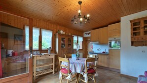 A wooden interior with a dining table, chairs, a chandelier, and wooden cabinets. - Ground-Floor Apartment for 4, 50 m from the Slopes in La Clusaz (La Clusaz)