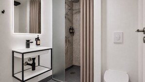 Ein modernes Badezimmer mit Waschbecken, Toilette und Duschbereich.
