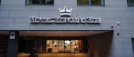 A hotel entrance with a crown logo, indicating a possible royal or prestigious establishment.