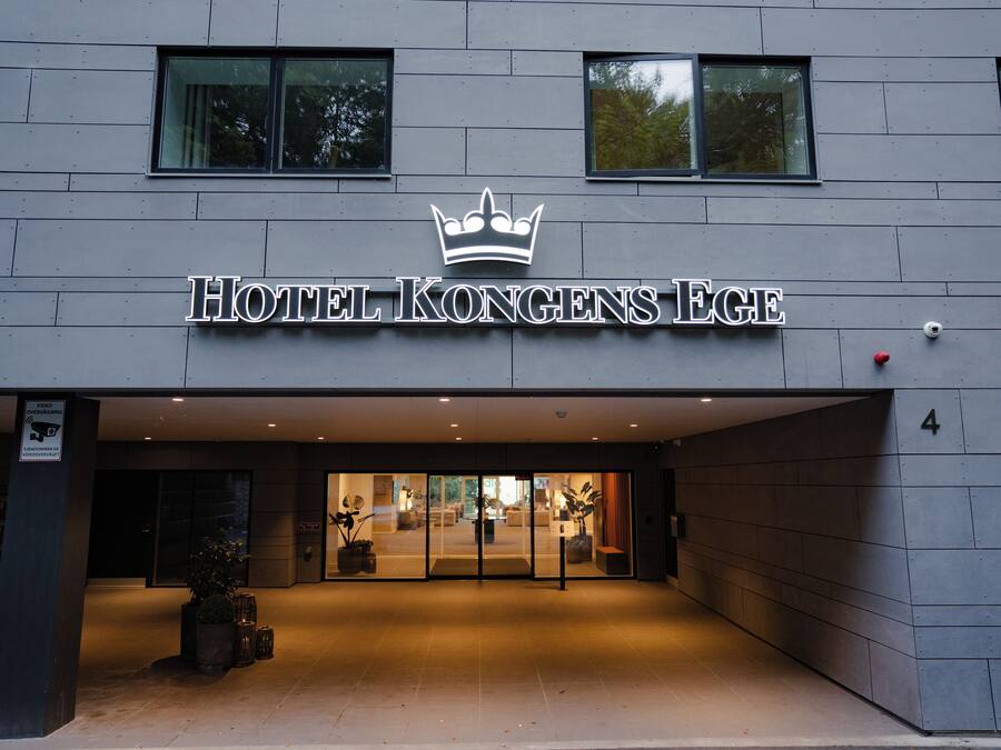 Entrada de hotel con un logotipo de corona, lo que sugiere un establecimiento de posible realeza o prestigio.