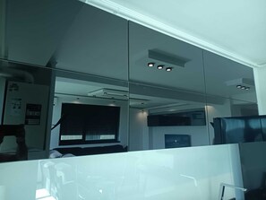 A modern office space with glass partitions, a visible window with blinds, and a ceiling with recessed lighting. - Florence Luxury Apartment Mamaia Beach Constanta Romania (Mamaia-Sat)
