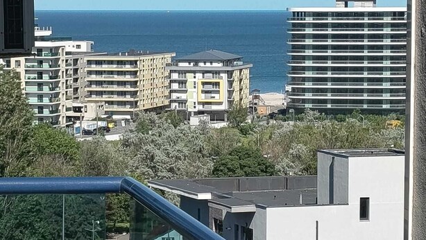 Ein Wohngebiet mit modernen Gebäuden, freiem Meerblick und einer Glasbrüstung.