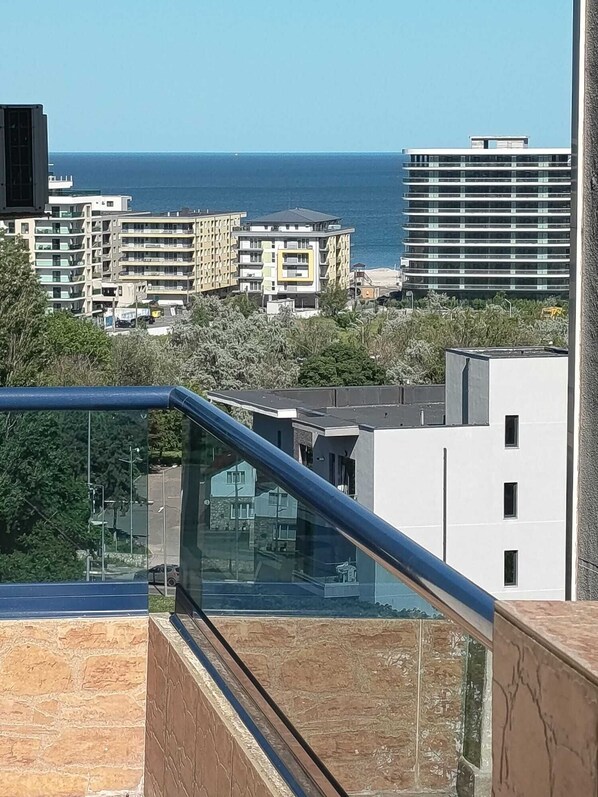 A residential area with modern buildings, a clear view of the sea, and a glass railing. - Florence Luxury Apartment Mamaia Beach Constanta Romania (Mamaia-Sat)
