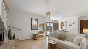Amplia sala de estar con sofá, mesa de centro y una escalera.