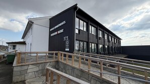 A modern building with a sign reading 'RYGGE APARTMENTS ROOM RENTAL' and the number 373. - Rygge Apartments (Moss)