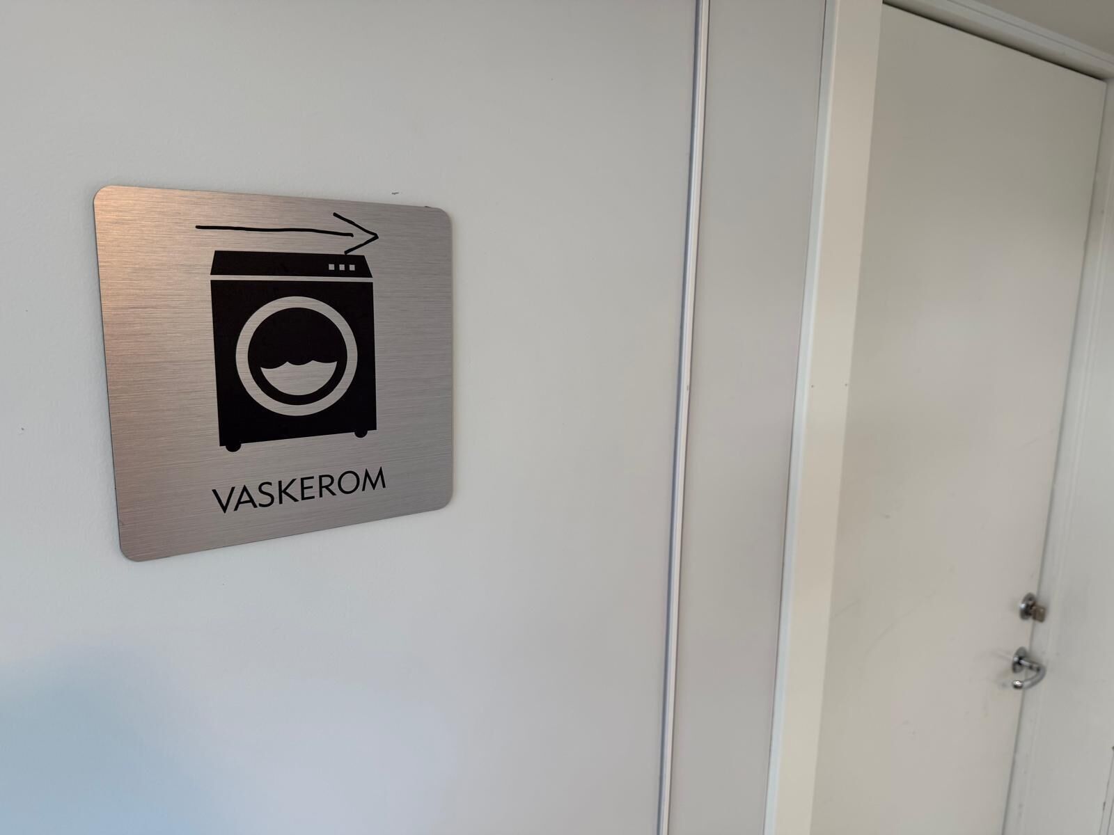 Ein Schild mit der Kennzeichnung Waschenmaschine und Tür.