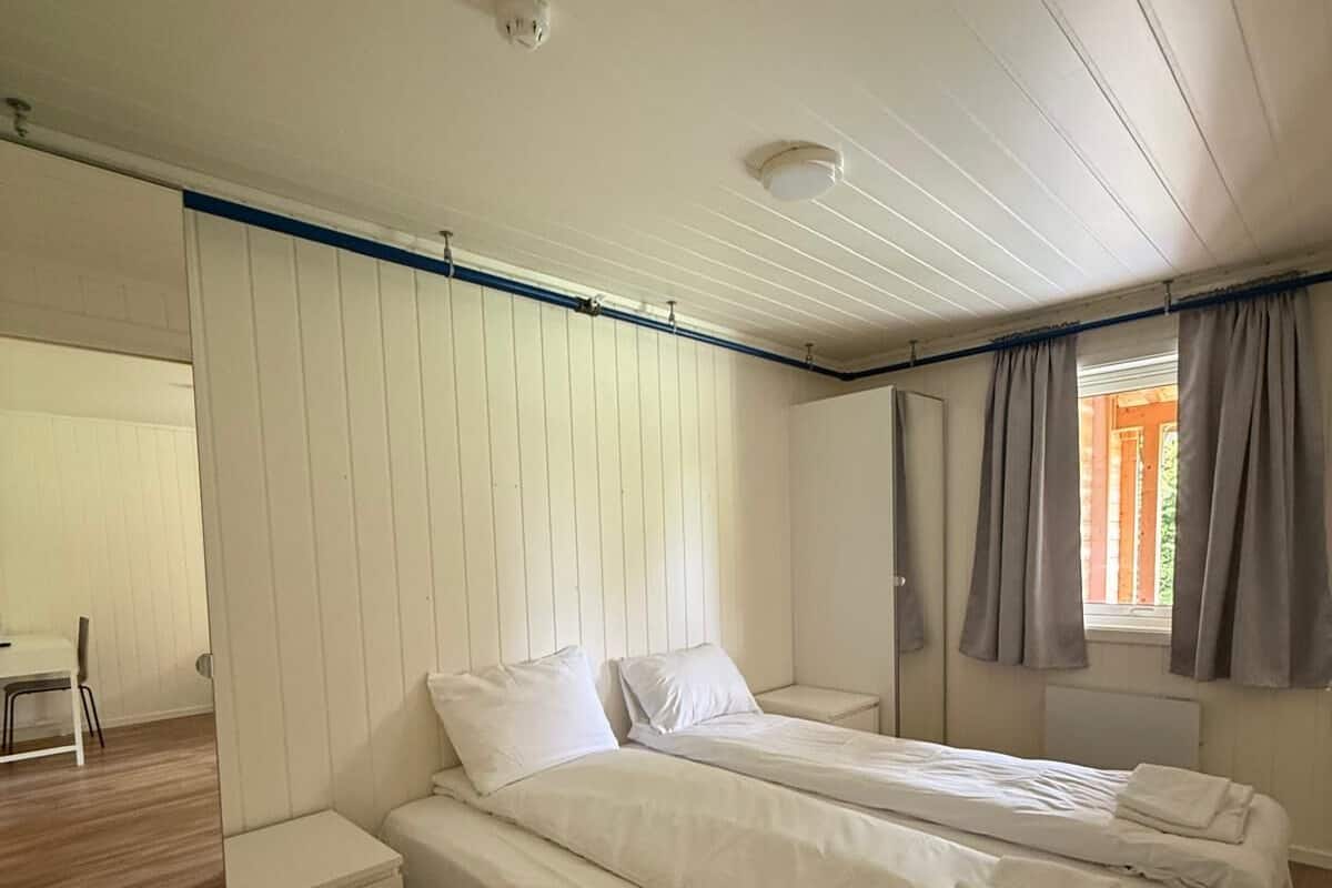 A room with two beds, a small table, and a chair.
