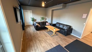 A living room with a sofa, a coffee table, and a potted plant.