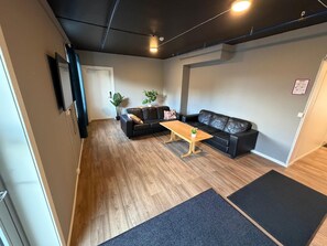 A living room with a sofa, a coffee table, and a potted plant.
