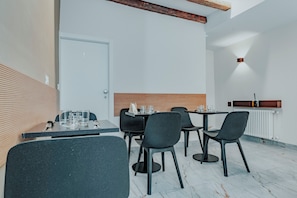Een moderne eethoek met een wand van houten latten, een witte deur en een tafel met stoelen.