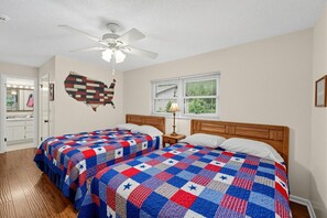 A bedroom with two beds, a ceiling fan, a window with blinds, and a wall map decoration. - Lakefront Frostproof Retreat with Private Beach (Frostproof)