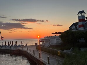 A waterfront promenade with a sunset view, a lighthouse, and a pier with seating. - The Homestead Glen Arbor Condo Lake Michigan (Glen Arbor)