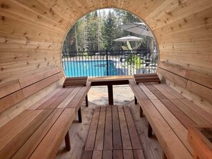 A wooden sauna with benches and a view of a swimming pool. - Game Room, Spa & Sauna | Le Drakkar (Shannon)