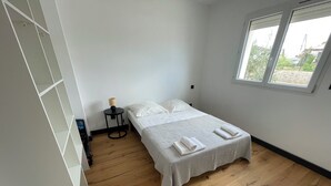 A bedroom with a bed, a small table with a lamp, and a window. - Luxury 5-bedroom villa Mountain view 5 minutes from the beach (Venzolasca)