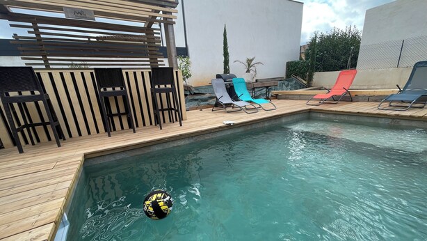 A pool area with wooden deck, lounge chairs, and a pergola. - Luxury 5-bedroom villa Mountain view 5 minutes from the beach (Venzolasca)