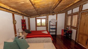 Una habitación con cama, escritorio, lámpara, ventana y puerta.