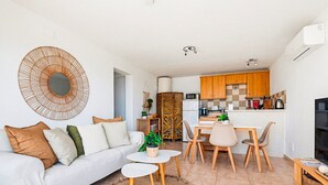 Een moderne woonkamer met een bank, salontafel en eethoek.