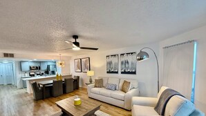 Un salon moderne avec un canapé, une table basse et un coin repas.