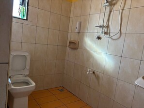 Een douche, handdoeken, zeep, toiletpapier