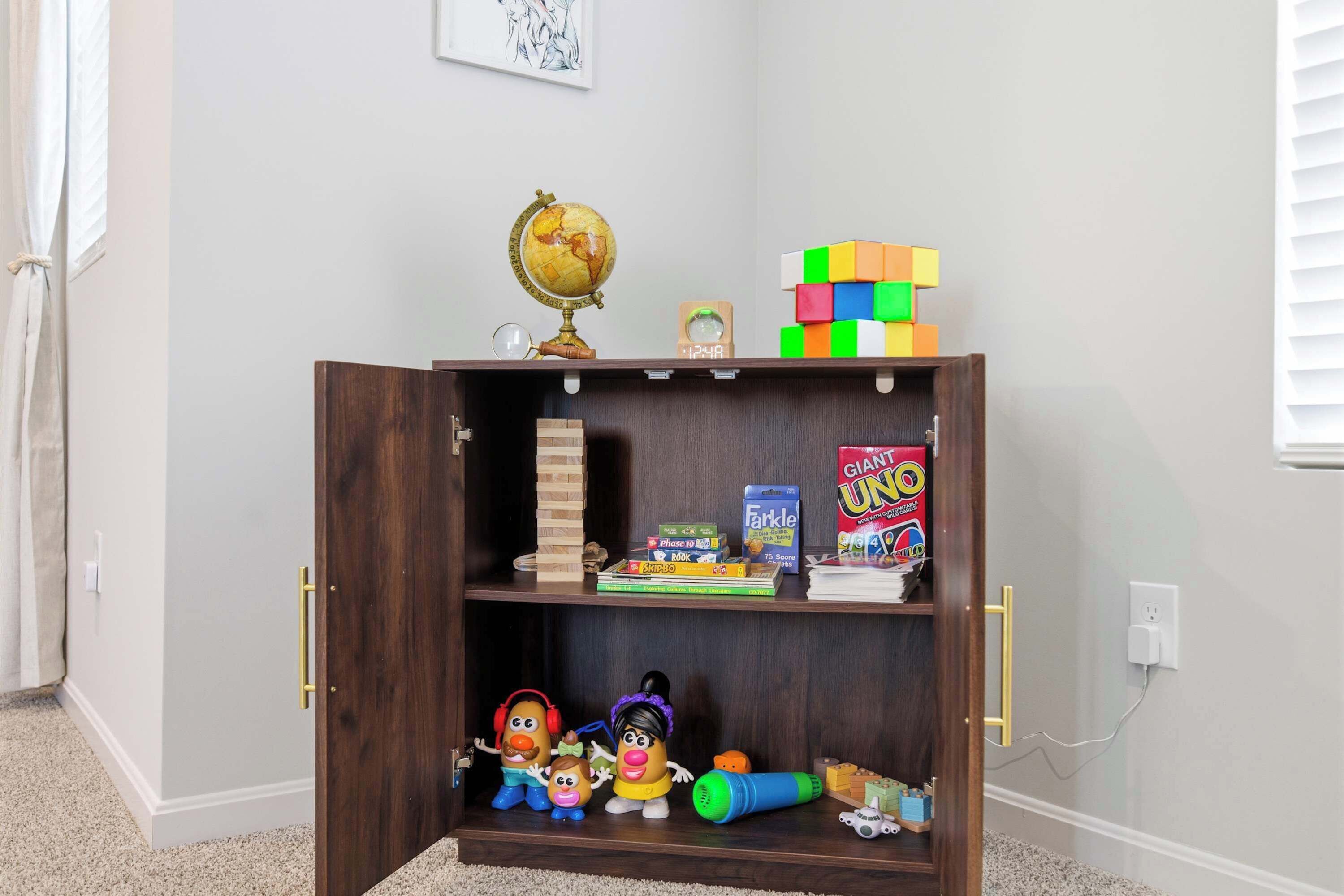 A wooden bookshelf with toys, a globe, and books.
