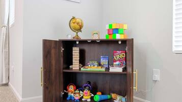 A wooden bookshelf with toys, a globe, and books.