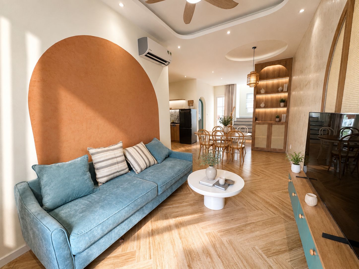 A modern living room with a sofa, coffee table, and dining area.