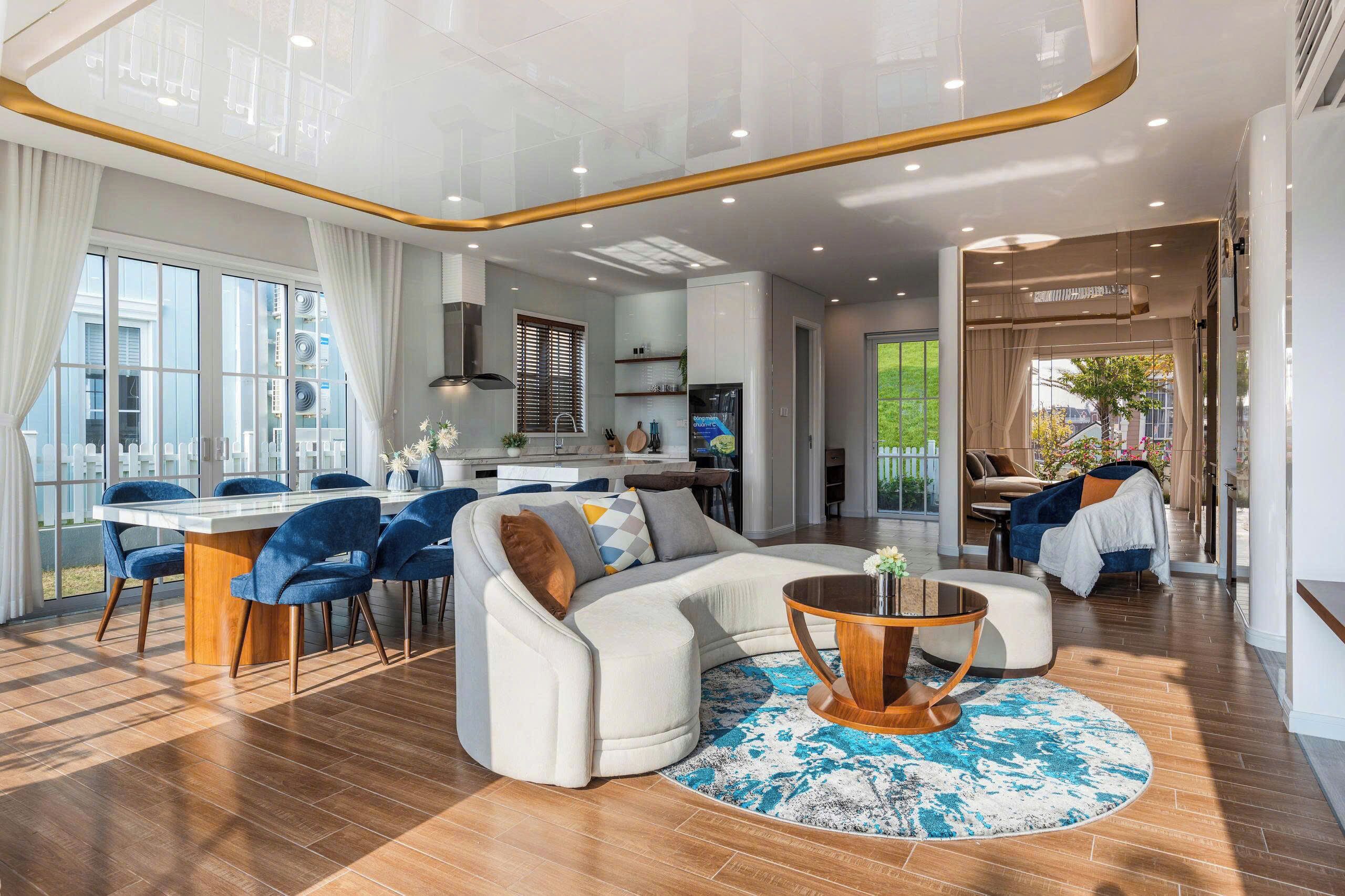 A modern living room with a sofa, coffee table, and dining area with chairs.
