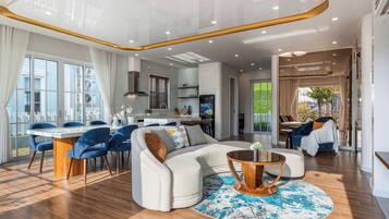 A modern living room with a sofa, coffee table, and dining area with chairs.