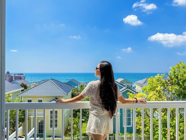 Ein Balkon mit Blick auf das Meer und Häuser.