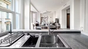 Cozinha moderna com uma janela grande, área de jantar com mesa redonda e vista para a cidade.