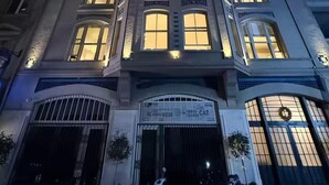Um edifício de vários andares com janelas iluminadas e portão.
