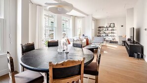 Uma área de refeições com uma mesa redonda, cadeiras e uma luminária pendente moderna.