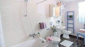 Un baño con bañera, ducha, lavabo e inodoro.