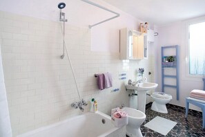 A bathroom with a bathtub, a shower, a sink, and a toilet. - Divine Villa Viani (Villa Viani)
