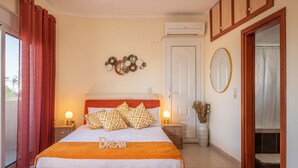 Een slaapkamer met een bed, nachtkastjes, een spiegel, een deur en een decoratie aan de muur.