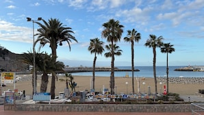 Una spiaggia con palme, un molo e un cartello per un ristorante chiamato 'El Tiburon'.