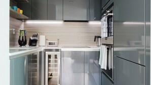 A modern kitchen with stainless steel appliances, a built-in oven, and a wine rack. - Sleek 1BDR Flat with Balcony Private Work Space (Greater London)