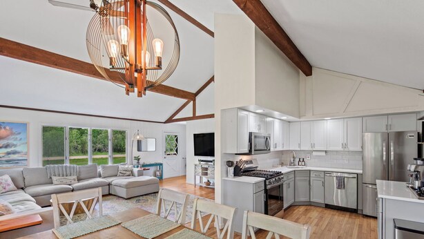 Amplia sala de estar con un sofá grande, mesa de comedor y cocina equipada con electrodomésticos modernos.