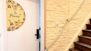 A staircase with a rope handrail and a door with a circular sign.