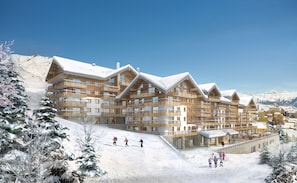 Un hotel de varios pisos con una pista de esquí en primer plano, fachada de madera y montañas nevadas al fondo.