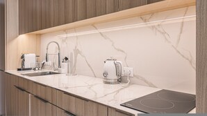 A modern kitchen with a marble backsplash, a built-in stove, and a coffee maker. - Marea Widok na Morze Studio Premium Hotel Seaside (gmina Parzęczew)
